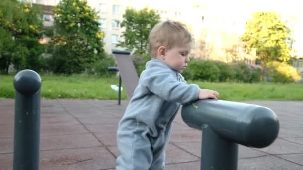 Adorável engraçado bebê jogar no parque infantil sob os cuidados de seus pais hipster — Vídeo de Stock