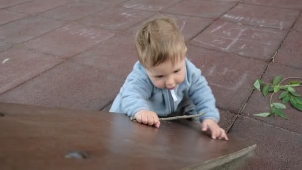 Schattig grappige baby spelen in Speeltuin onder zorg van zijn ouders hipster — Stockvideo