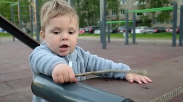 Adorable jeu drôle de bébé à l'aire de jeux sous les soins de ses parents hipster — Video