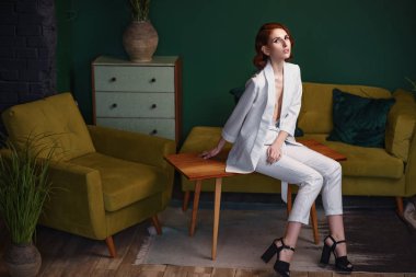 Güzel redhead ince genç kadın içinde beyaz laubali pantolon takım elbise