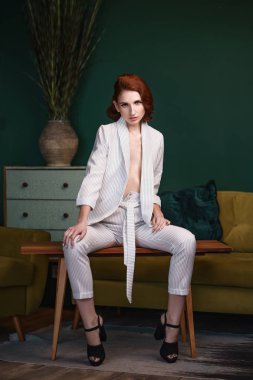 Güzel redhead ince genç kadın içinde beyaz laubali pantolon takım elbise