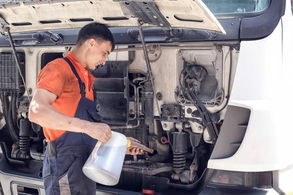 Mechanic changes engine oil and diesel truck filter