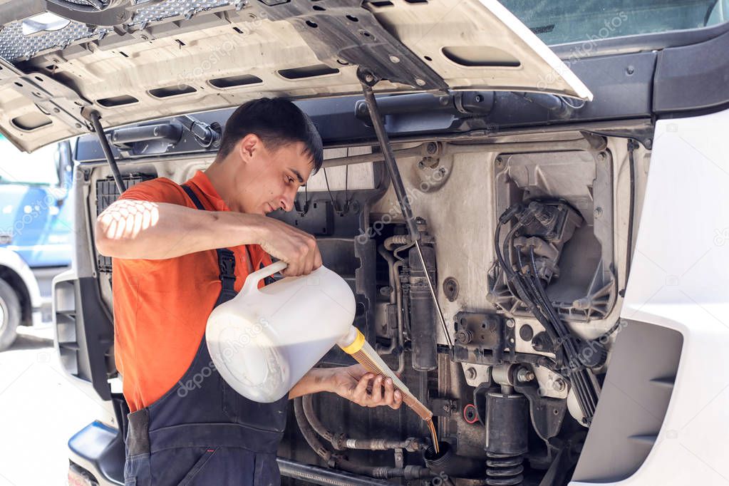 Mechanic changes engine oil and diesel truck filter