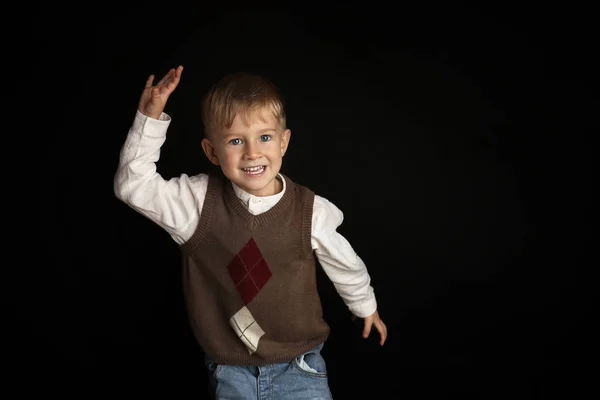 ジーンズに身を包んだ3 4歳の金髪の男の子の肖像画白いシャツと鉄の笑顔がかわいい ソフトライトのスタジオで撮影された背景には 興味深い表情と劇的な — ストック写真