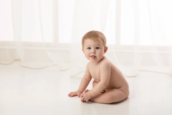 赤ん坊は裸で白い背景に座っている スタジオショット — ストック写真