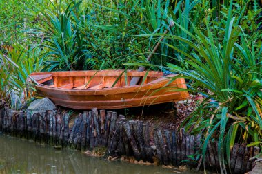 Çimde nehir kıyısında gizli küçük ahşap Kano