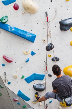 Bir adam onun kavrama yükselme orta kapalı rock duvardaki kaybettikten sonra dinlenme.
