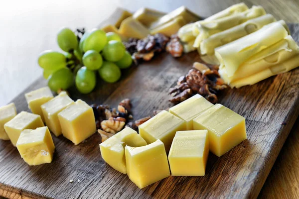 一套不同的奶酪放在木板上 奶酪板 美味的小吃 健康而独特的食物 奶酪套装 — 图库照片