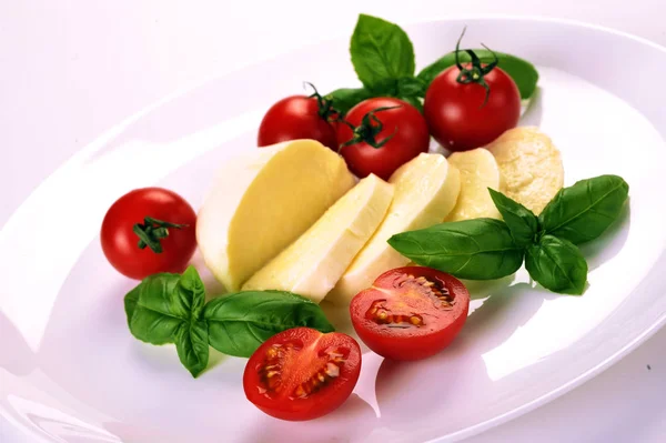 白い皿にモッツァレラチーズ チェリー トマト バジル — ストック写真