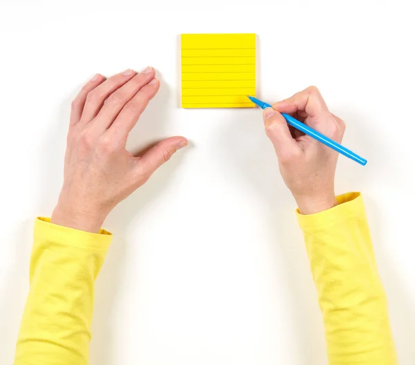 Hand Und Gelbes Papier Auf Dem Tisch Auf Weißem Hintergrund — Stockfoto