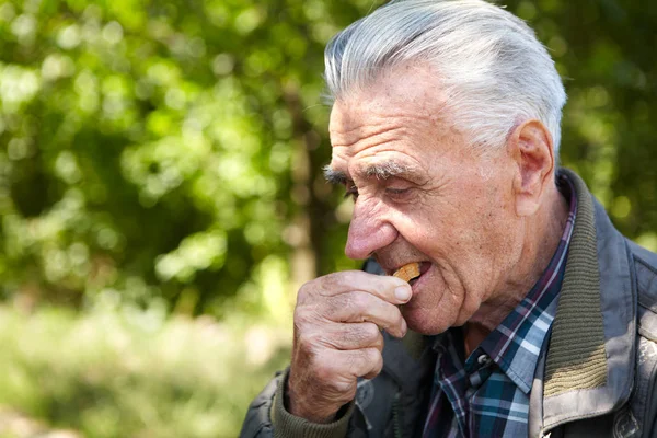 Povero anziano che mangia pane — Foto Stock