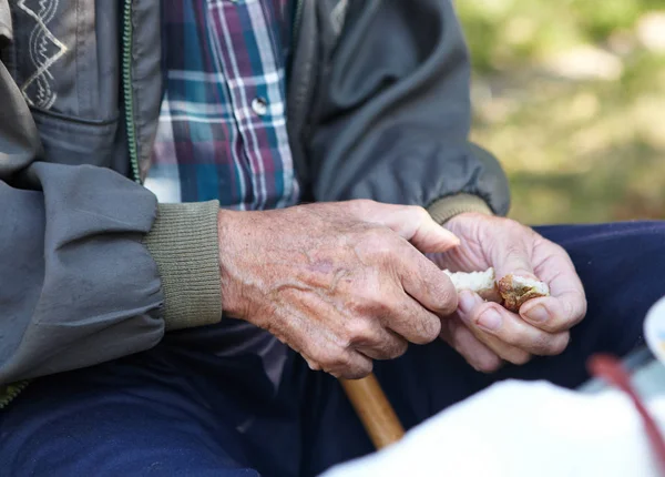 Elderly poor man eating bread — Stock Photo, Image