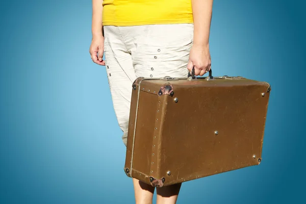 Woman in a yellow T-shirt stands with a suitcase in her hand — Stock Photo, Image