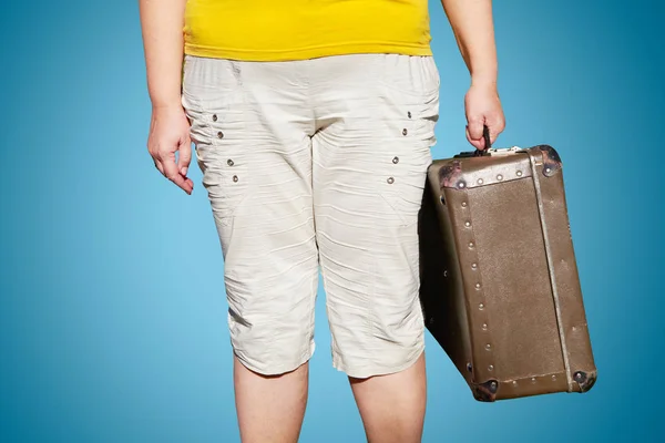 Woman in a yellow T-shirt stands with a suitcase in her hand — Stock Photo, Image