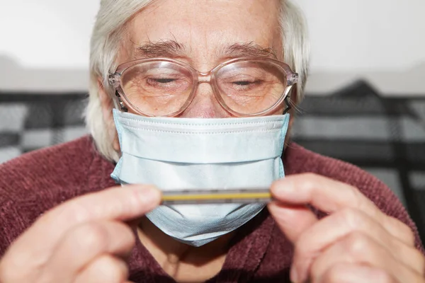 Äldre Kvinna Medicinsk Mask Epidemin Och Termometern Stockbild