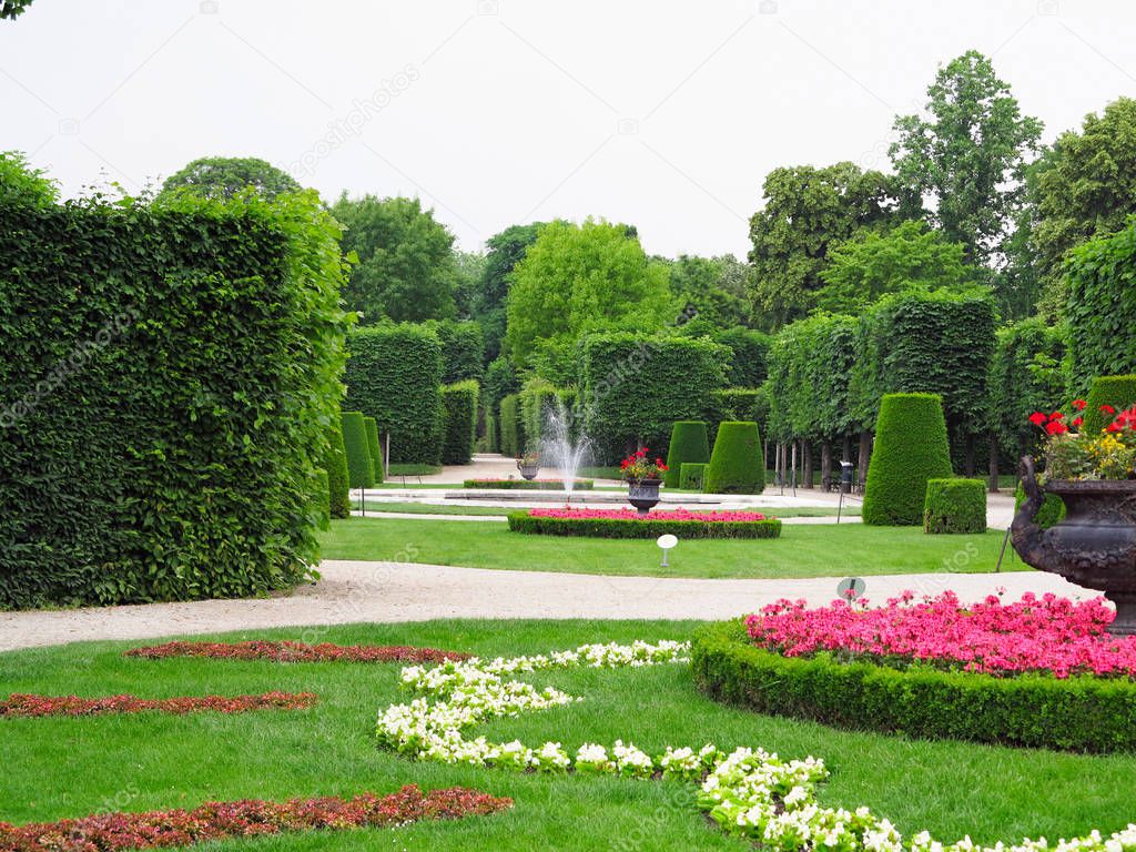 Abstract ideal flower beds and shorn trees in a well-kept park