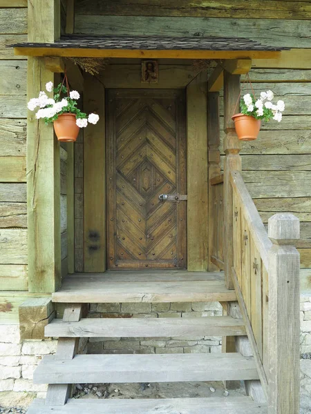 Front view of a vintage wooden front door porch with flowers decorations