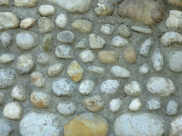 Bakgrunnsstruktur på gammel, rund, grå steinvegg – stockfoto