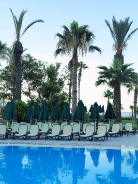 Eğlence için bir yüzme havuzunun su önünde şezlonglar.