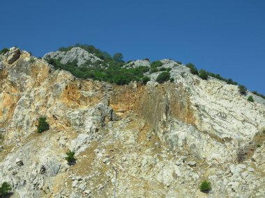 Mavi gökyüzü arka plan üzerinde yüksek kaya dağları