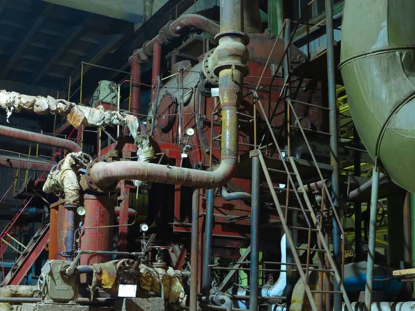 Pipes, steel tubes, steam turbine and equipment at industrial power plant, night scene