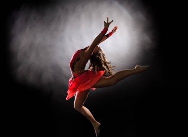 Genç güzel dansçı jimnastik stüdyoda atlama