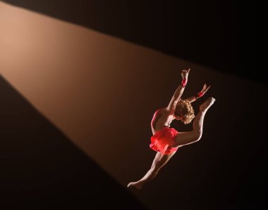 Genç güzel dansçı jimnastik stüdyoda atlama