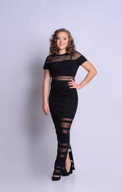 Elbiseli genç güzel kız. Stüdyo resmi, gri arka plan