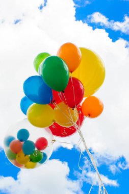 Mavi gökyüzü arka plan üzerinde parlak renkli balonlar