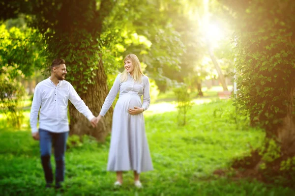 Felice e giovane coppia incinta a piedi all'aperto — Foto Stock