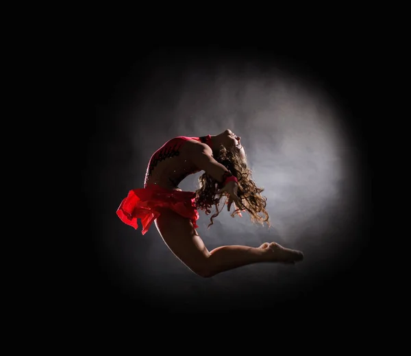 Young beautiful dancer gymnastics jumping in studio — Stock Photo, Image