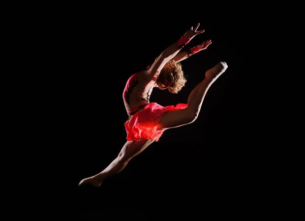 Young beautiful dancer gymnastics jumping in studio