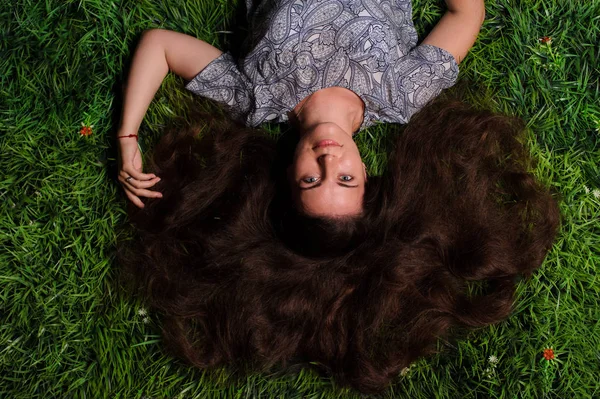 Kvinna som ligger på ett grönt gräs utomhus — Stockfoto