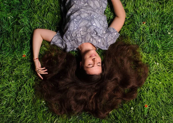 Kvinna som ligger på ett grönt gräs utomhus — Stockfoto