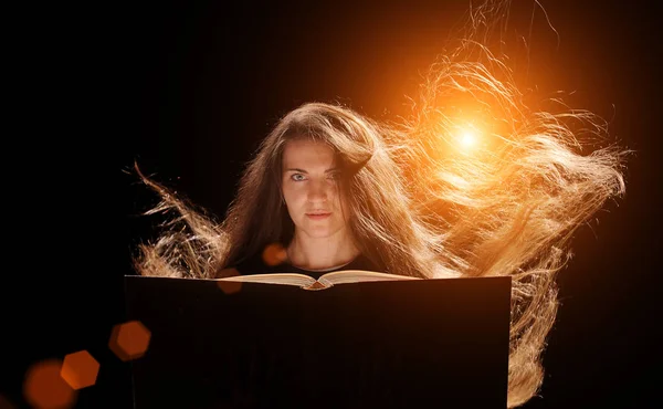 Magic Woman reading a book. black background — Stock Photo, Image