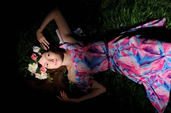 Jovem mulher em grinalda de folwers em uma grama verde — Fotografia de Stock