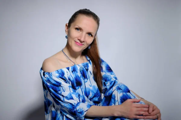 Retrato de mujer bonita en vestido azul sobre fondo gris — Foto de Stock