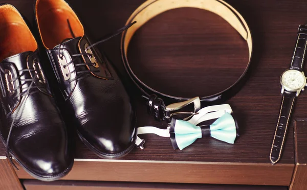 Wedding details. Groom accessories. Shoes, rings, belt, and bowt