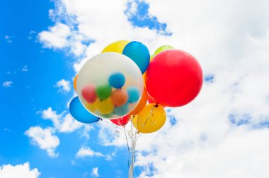 Mavi gökyüzü arka plan üzerinde parlak renkli balonlar