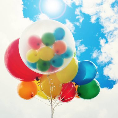 Mavi gökyüzü arka plan üzerinde parlak renkli balonlar