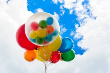 Mavi gökyüzü arka plan üzerinde parlak renkli balonlar