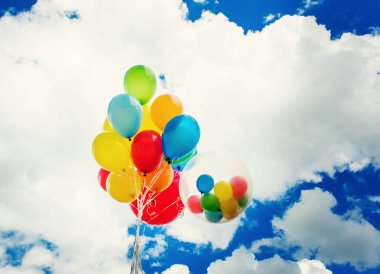 Mavi gökyüzü arka plan üzerinde parlak renkli balonlar