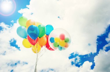 Mavi gökyüzü arka plan üzerinde parlak renkli balonlar