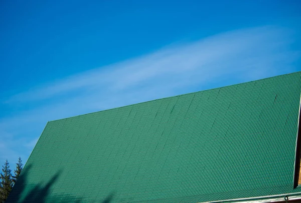 青空の上に緑の金属タイルの屋根 — ストック写真