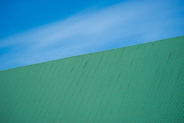 Mavi gökyüzü üzerinde yeşil metal fayans çatı — Stok fotoğraf