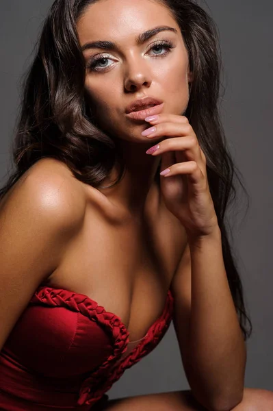 Splendida donna in abito rosso. Studio foto, sfondo grigio — Foto Stock