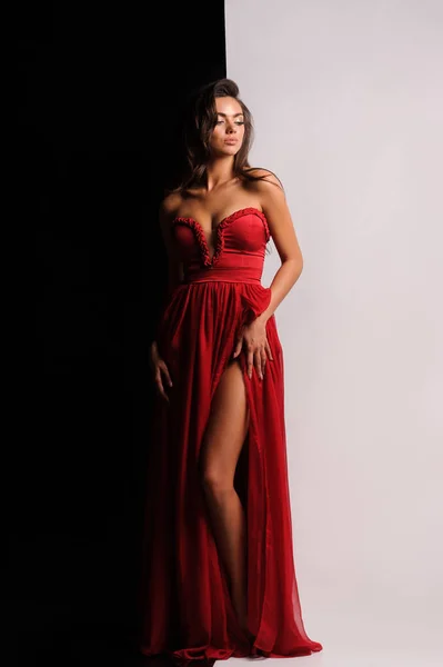 Magnifique femme en robe rouge. Studio photo, fond gris — Photo