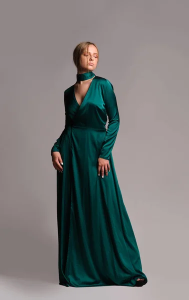 緑のドレスを着たかわいい女の子。スタジオ画像、灰色の背景 — ストック写真