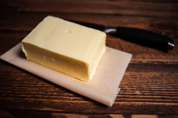 Кусок масла на деревянном столе — стоковое фото