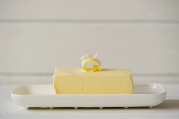 Pedaço de manteiga em uma mesa de madeira — Fotografia de Stock